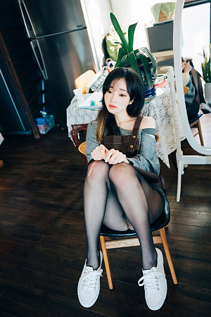 Asian girl in sheer black pantyhose takes off her dress in a small cozy cafe