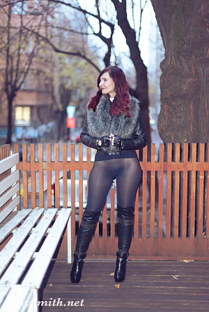 Jeny poses on a city street wearing just a stylish jacket, black seamless pantyhose and tall boots, her feminine curves and private areas fully on display